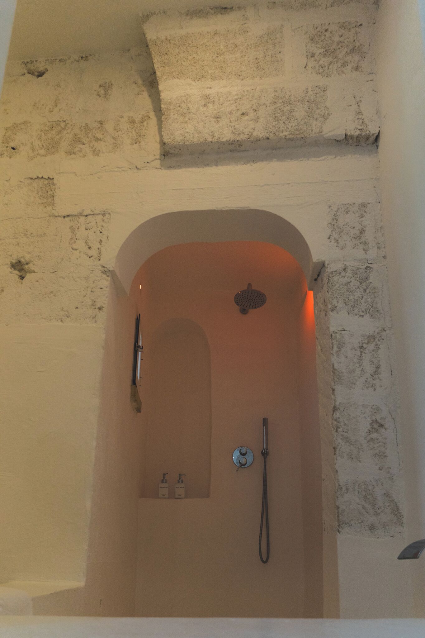 A bathroom with a bathtub, a shower, and a hand dryer.
