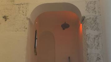 A bathroom with a bathtub, a shower, and a hand dryer.