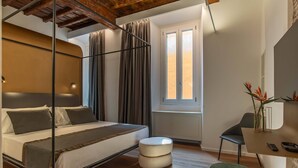 A bedroom with a bed, a desk, a chair, and a window. - Ora Acanfora Suites (Rome)