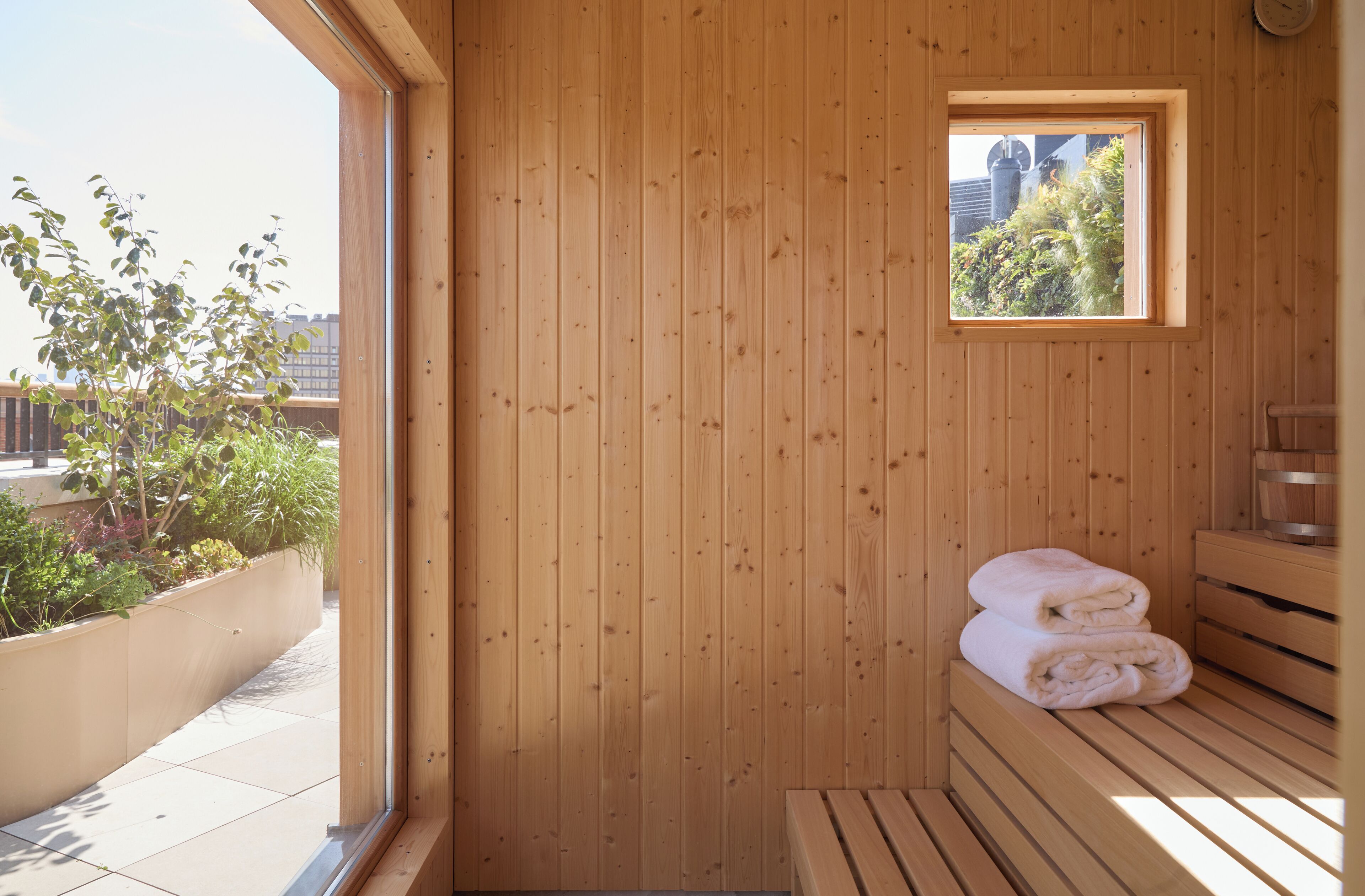 A wooden sauna with a bench and a small window.