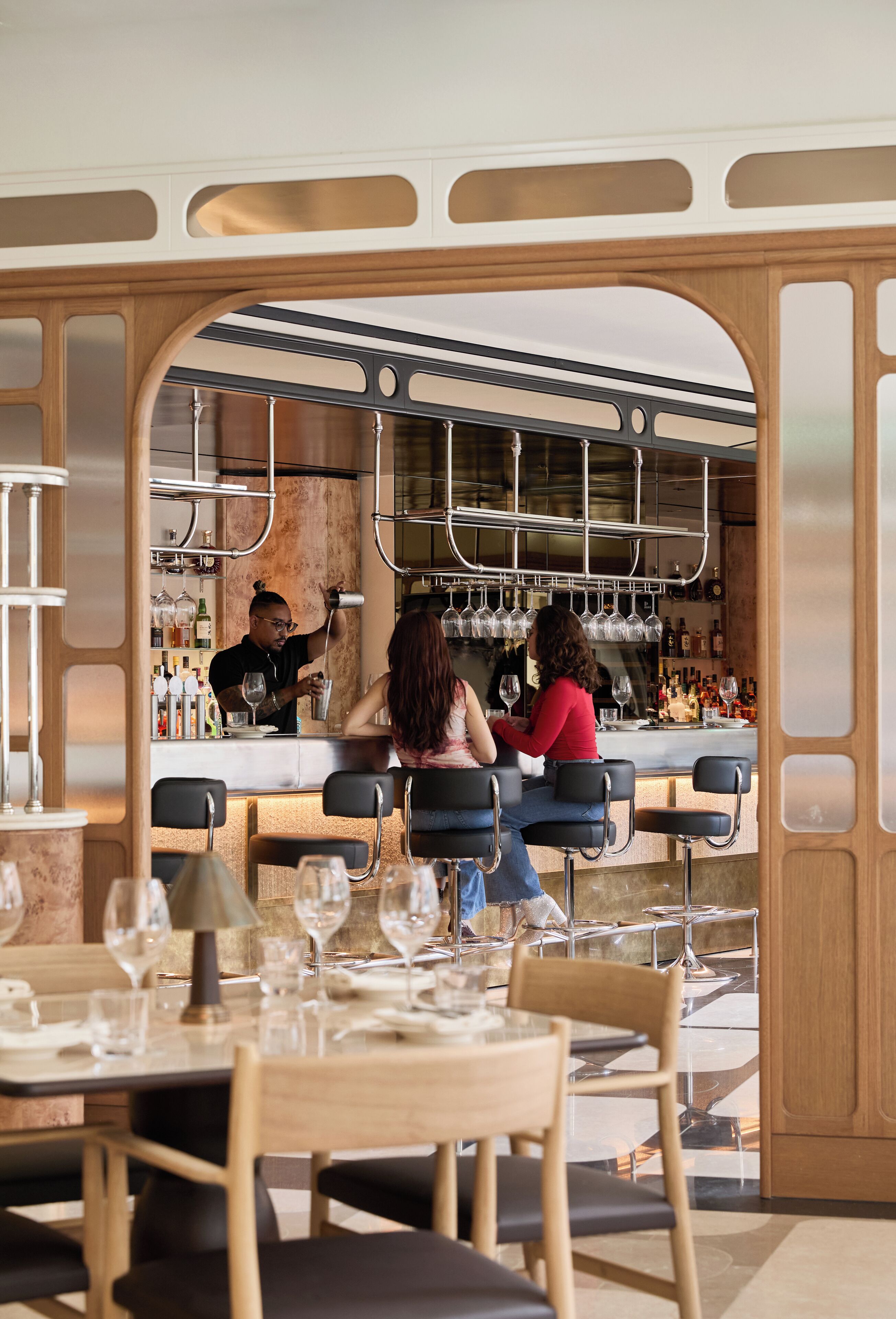 A bar area with a counter, stools, and a seating area with tables and chairs.