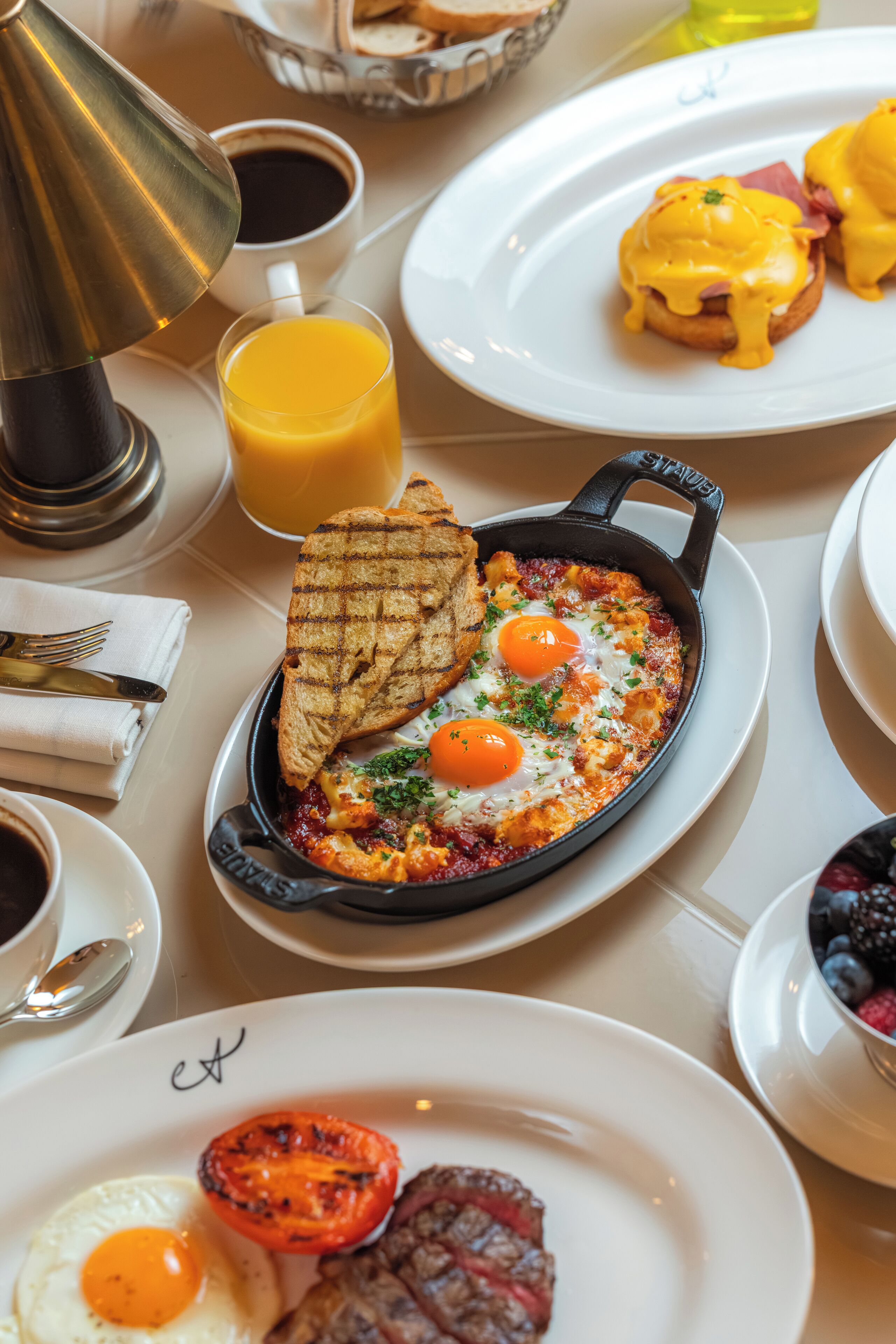 A breakfast setting with eggs, toast, and a skillet dish on a table.