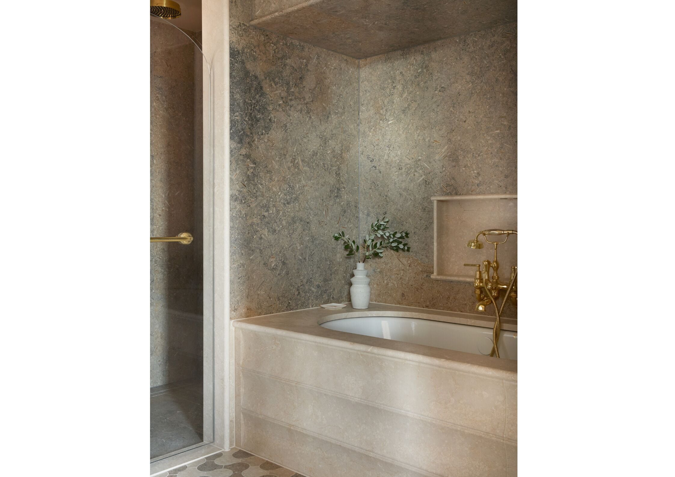 A bathroom with a bathtub, a shower, and a small potted plant.