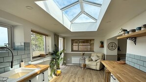 A modern kitchen with a skylight, wooden flooring, and a view of the outdoors. - Kennel House with Hill Views perfectly situated for walks. - 20 min to the beach (Whitland)