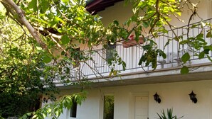 A two-story building with a balcony, outdoor seating, and potted plants. - Landhaus (Lützen)