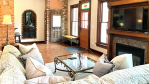 Una sala de estar acogedora con chimenea, asientos cómodos y televisor.