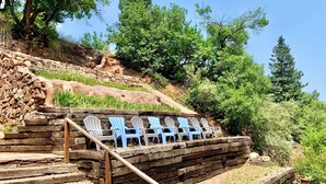 Escalones de madera al aire libre que conducen a una zona de estar con sillas blancas y azules.