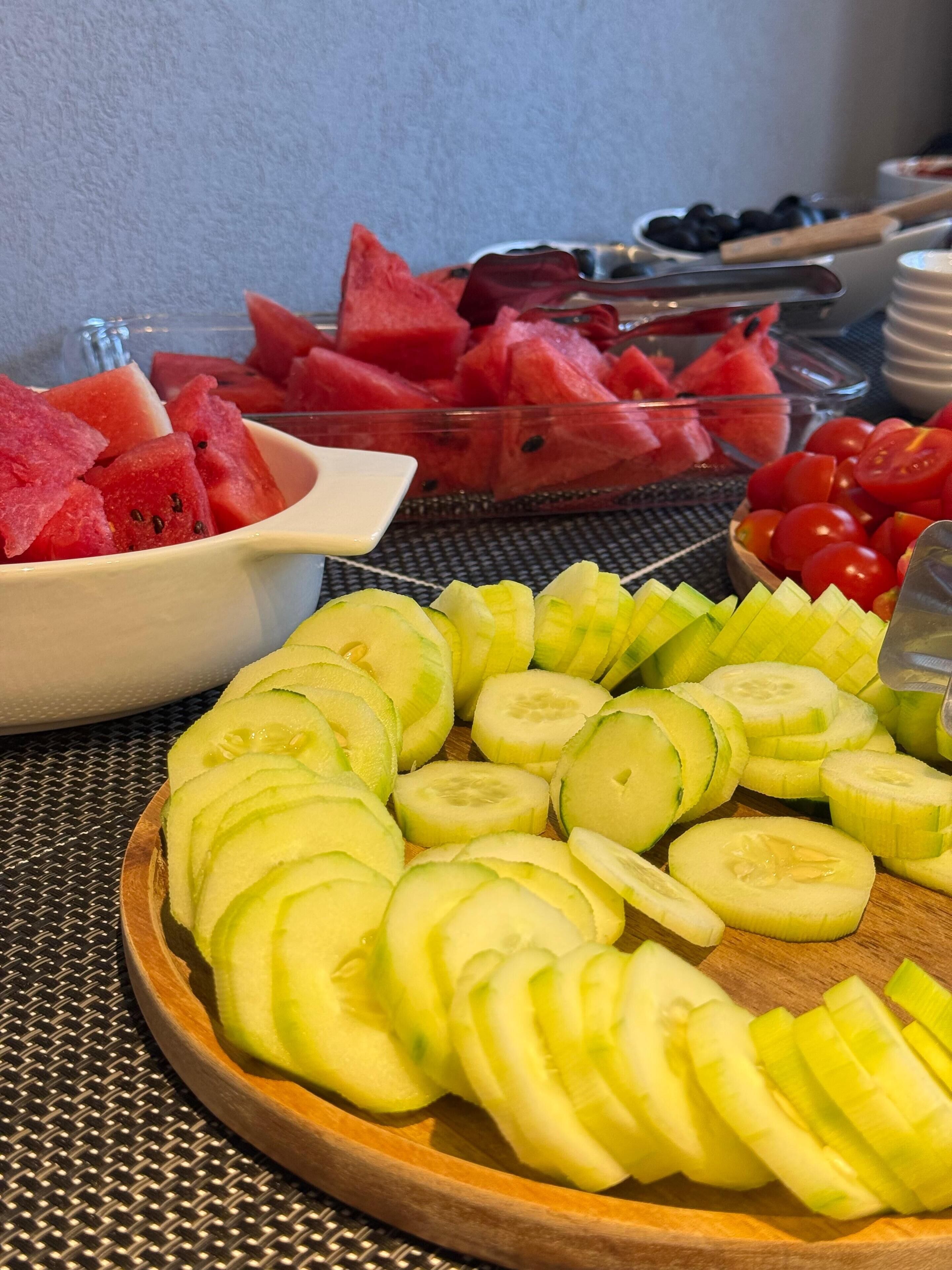 Ein Tisch mit Gurkenscheiben, Wassermelone und Tomaten.