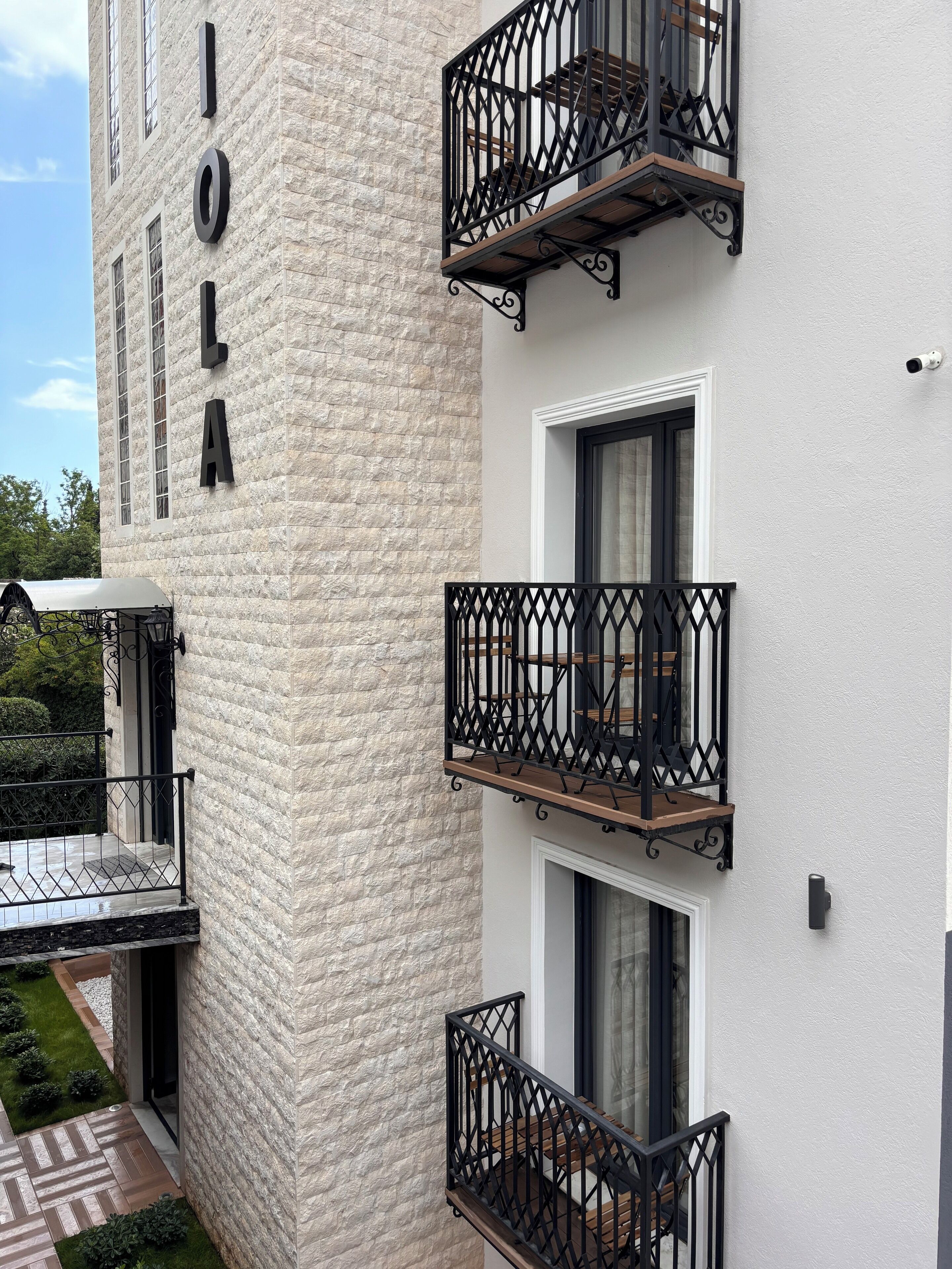 A building with a textured facade and balconies with wrought iron railings.