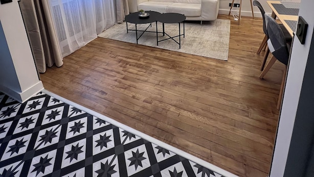 A modern living room with a sofa, a coffee table, and a dining area with a table and chairs. - Appartement Familial 6 Personnes (Nancy)