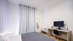 A modern hotel room with a large bed, a desk with a computer, and a chair. - Ca dei Gianchi 3 Apartment with 2 rooms and private parking with video surveillance (La Spezia)