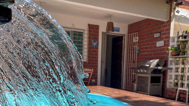 A swimming pool with clear water and a visible water spout. - Casa com Piscina a 40 metros do Mar by La Playa (Ipojuca)