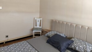 A bedroom with a bed, a chair, and a headboard. - Appartement Alger vue sur Mer (Hussein Dey)
