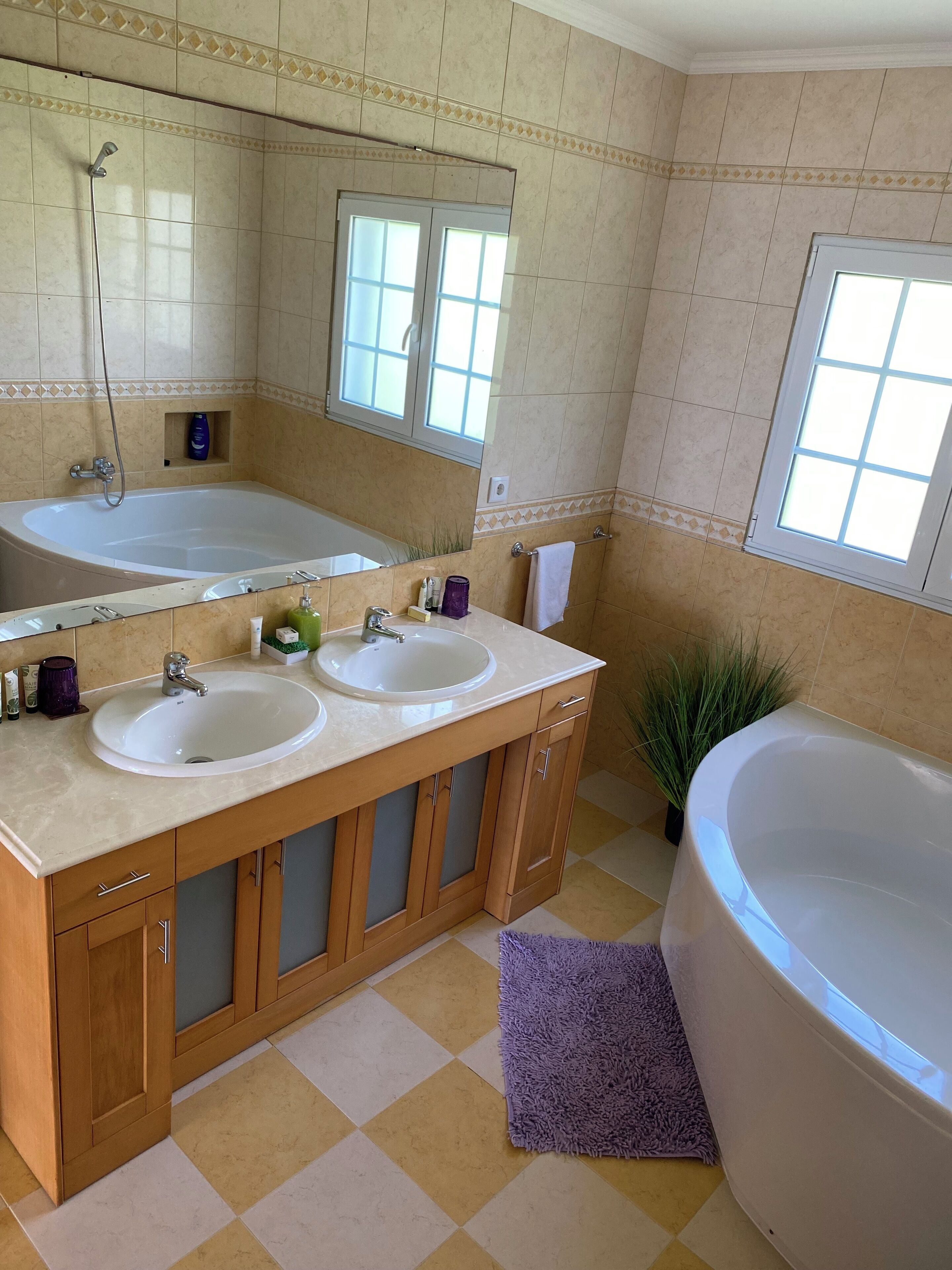 Ein Badezimmer mit zwei Waschbecken, einer großzügigen Badewanne und einer Dusche.
