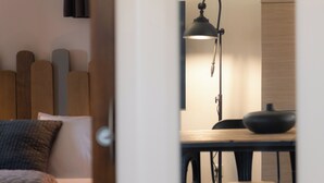 Une chambre à coucher avec un lit, une table de chevet et un bureau avec une lampe.