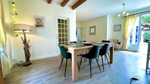 Un comedor con una mesa y sillas de madera, una lámpara y vistas al exterior.