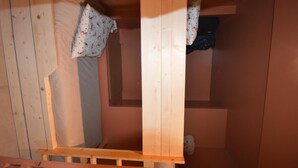 A small, single-room cabin with a wooden bunk bed, a small window, and a door. - 30m from ski lifts, 2nd floor, view ski slopes, terrace, tv, ski locker, 19m², Montalbert (La Plagne)
