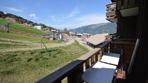 A balcony with a view of a town, including buildings and a grassy area. - 30m from ski lifts, 2nd floor, view ski slopes, terrace, tv, ski locker, 19m², Montalbert (La Plagne)