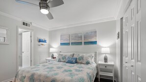 A bedroom with a bed, nightstands, a ceiling fan, and artwork on the wall. - Crescent Sands of WH-H2 3Br OF Condo (North Myrtle Beach)