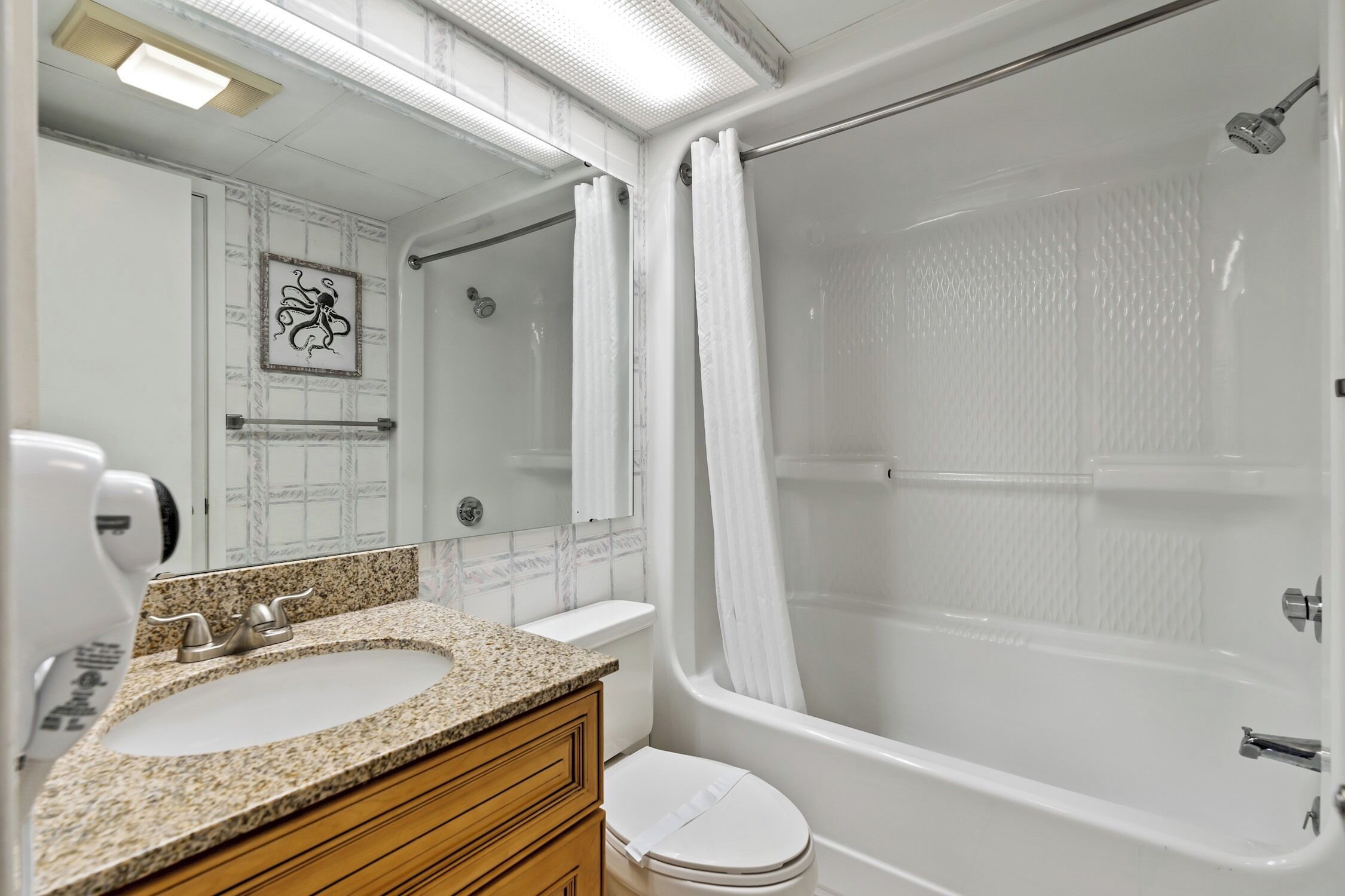 Ein Badezimmer mit Waschbecken, Ablagefläche, Toilette und Badewanne.