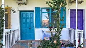 A building with a blue door, a purple door, and a blue window. - Gaya Pansiyon (Kemer)