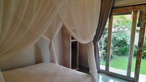 Un dormitorio con cama con dosel, vistas al jardín y un ventanal grande.