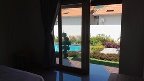 Una habitación con un amplio ventanal corredizo que da a una zona de piscina.