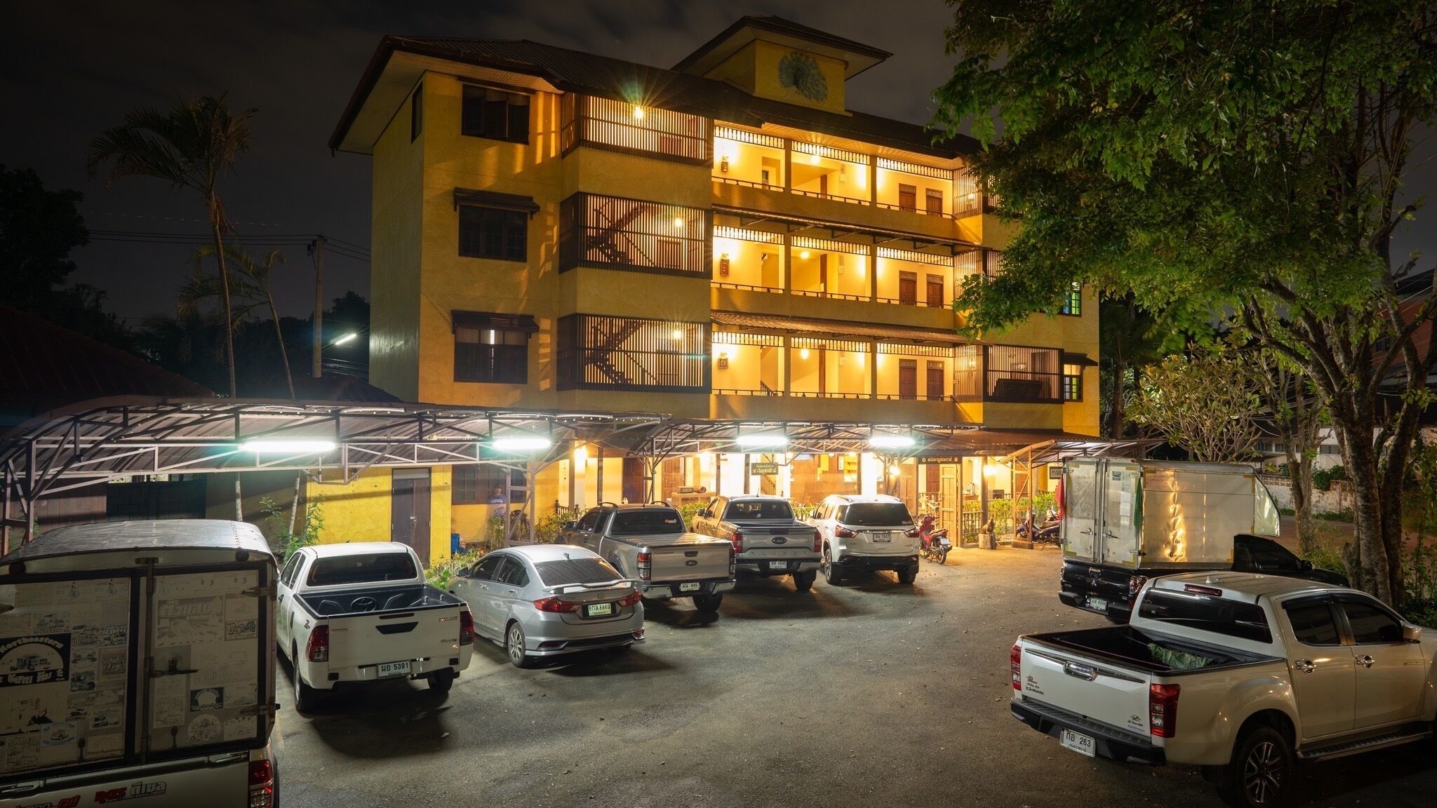 A multi-story hotel with a parking area filled with vehicles.