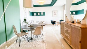 Un comedor moderno con una mesa redonda, sillas y un aparador tipo buffet.