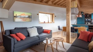 Ein gemütliches Wohnzimmer mit einer Couch, einem Couchtisch und einem Essbereich mit Stühlen und Tisch.