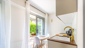 A modern kitchen with a white countertop, a gold faucet, and a small sink. - Lavie Maison Cozy Balneo Sauna (Bordeaux)