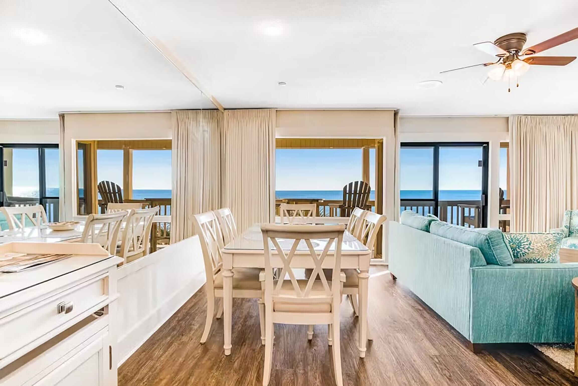 A spacious room with a dining area, a sofa, and a view of the ocean.