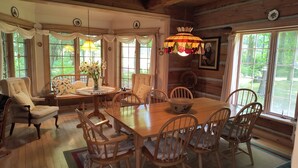 A cozy dining area with a wooden table, chairs, and a vase of flowers.