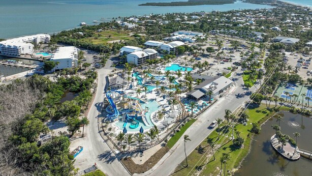 Luchtbeeld van een resort met een waterpark, meerdere zwembaden en een jachthaven.
