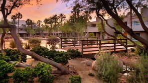 A resort with multiple buildings, a wooden bridge, and landscaped gardens.