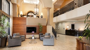 A spacious lobby with a fireplace, seating area, and a reception desk.