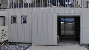 Ein zweigeschossiges Haus mit befahrbarer Auffahrt und einem kleinen Balkon.