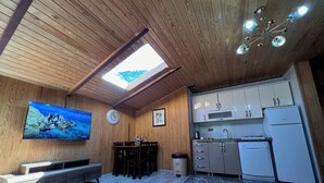 A modern kitchen with wooden cabinetry, a built-in oven, and a sink. - DİLEK APART (Çaykara)