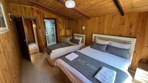 A wooden-paneled room with two beds, a shower, and a wooden ceiling. - DİLEK APART (Çaykara)