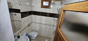 A small bathroom with a toilet, a sink, and a shower. - DİLEK APART (Çaykara)