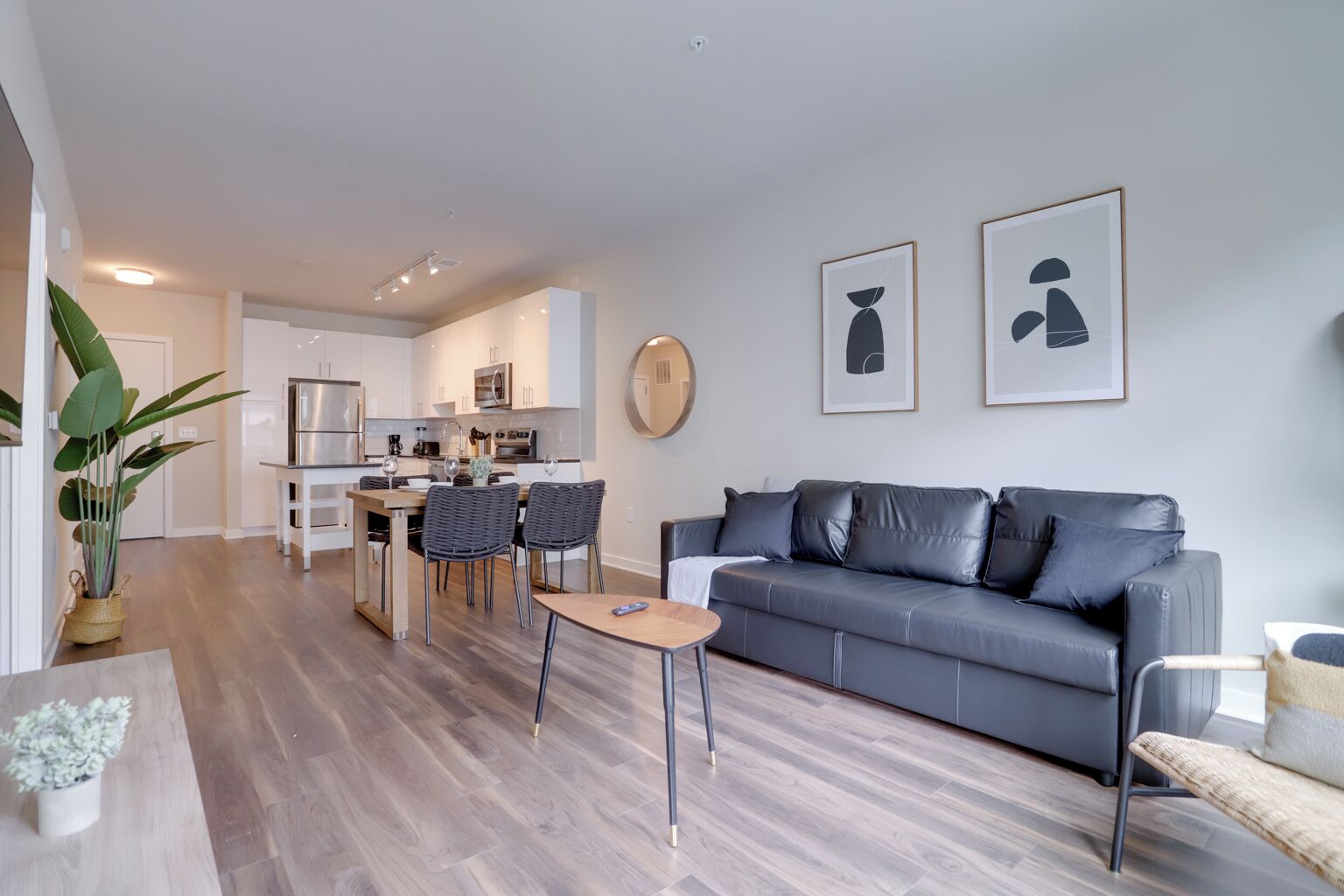 A modern apartment with a living room, dining area, and kitchen.