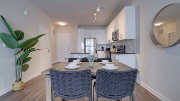 A modern kitchen with white cabinets, stainless steel appliances, and a central island.