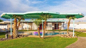 A modern hotel with a pool, covered patio, and palm trees. - HUGE YARD + Pool|Billiards|PingPong|Putting Green (Scottsdale)