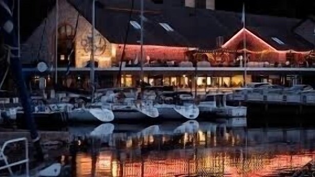 A waterfront building with a prominent red-lit structure, reflecting on the water. - Maison Entièrement Rénovée Avec Billard en Plein Cœur du Légué et à 5 min Plage (Plérin)