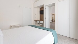 A modern hotel room with a bed, a desk, and a wardrobe. - La Piccola Corte - Appartamento1 by BarbarHouse (Maruggio)