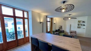 A modern kitchen with a wooden countertop, black chairs, and pendant lighting. - Spacious apartment in the heart of Gerardmer (Gérardmer)