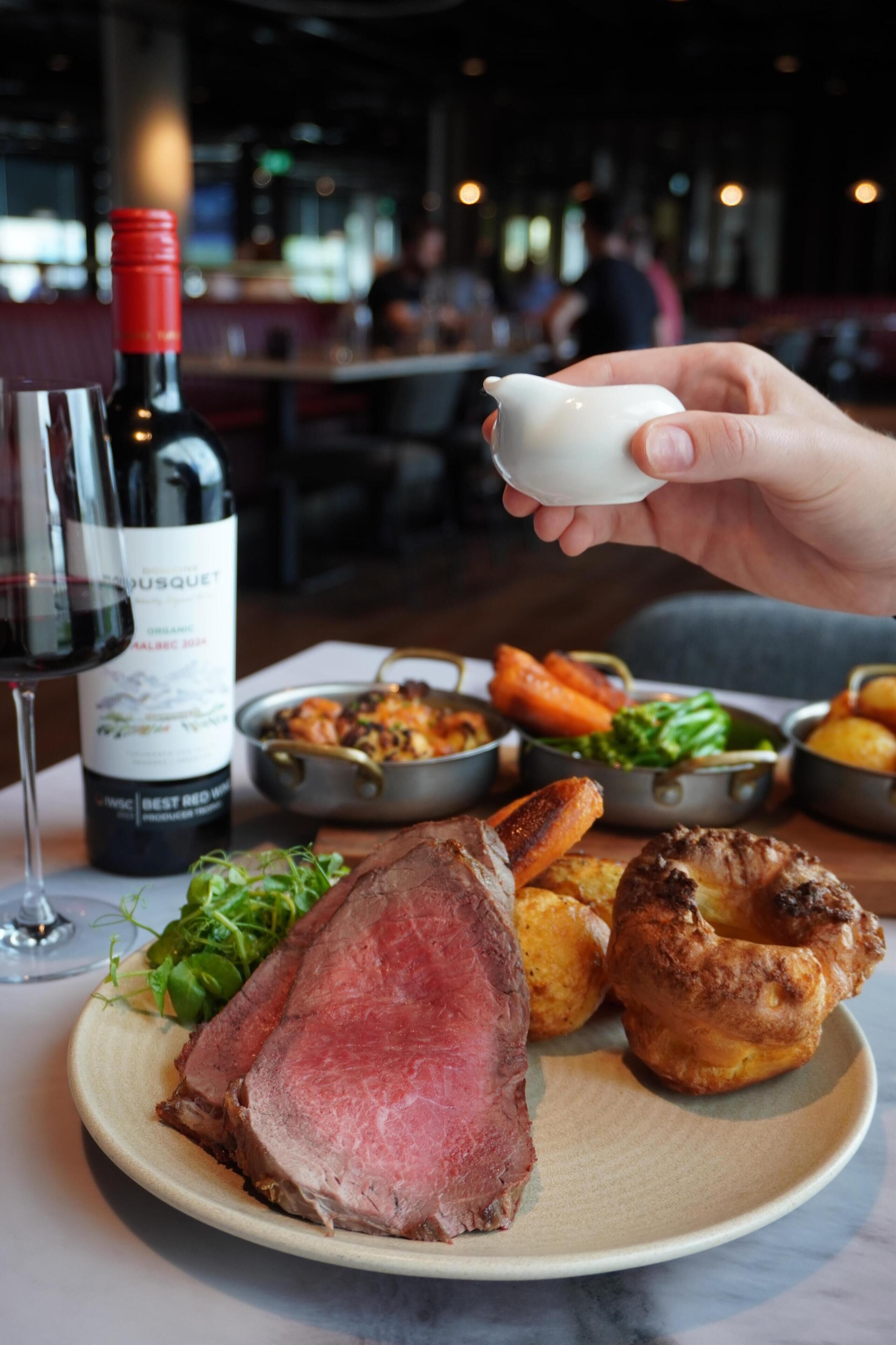 A plate of food with a bottle of wine and a glass of wine.