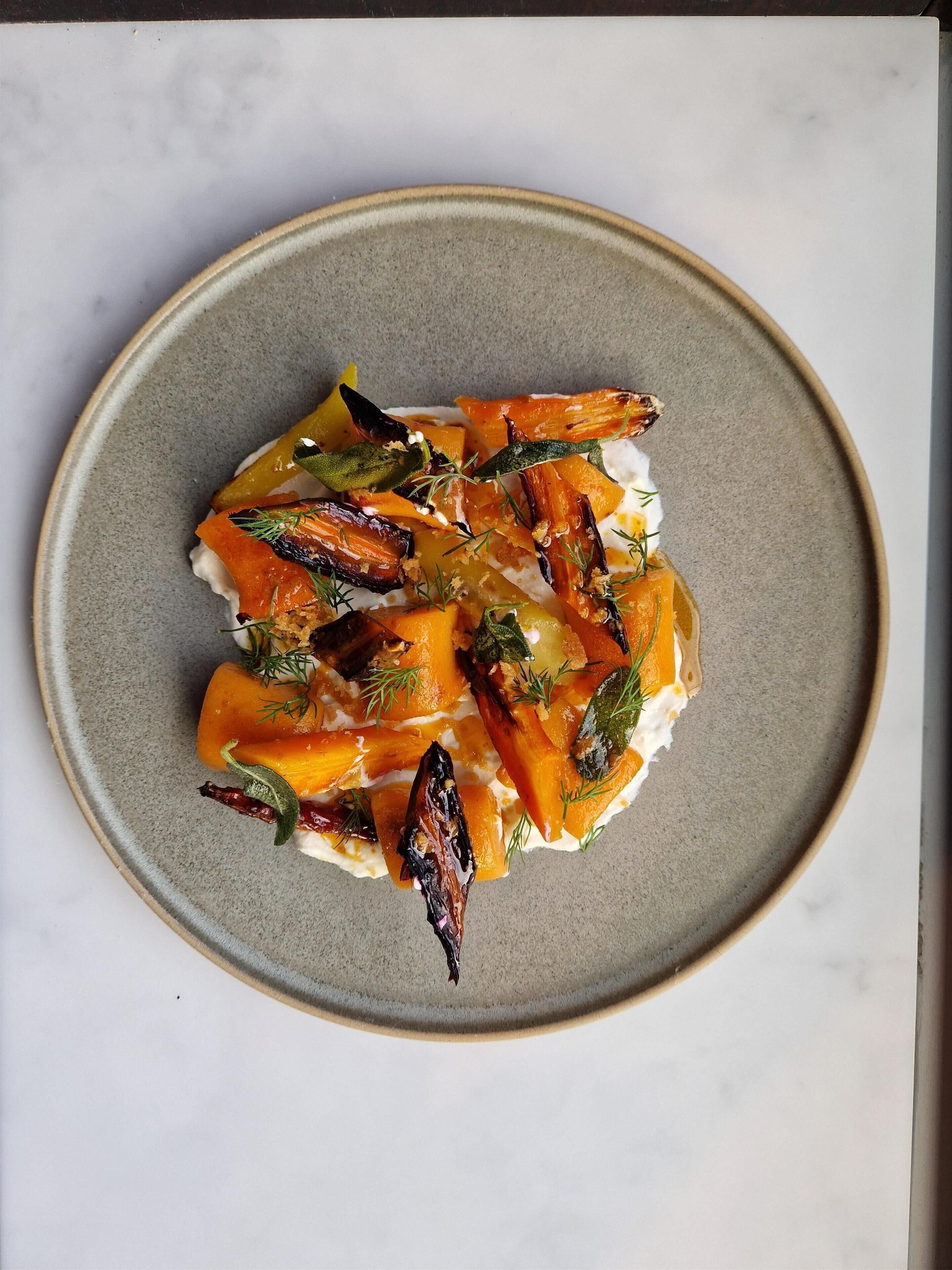 A plate of roasted vegetables on a ceramic plate.