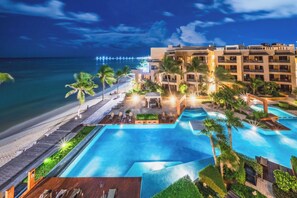 A resort with a large swimming pool, a beach, and a view of the ocean. - Surf 301 - Luxury Oceanview Beachfront (Playa del Carmen)