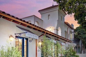 A traditional building with a white facade, arched windows, and a balcony with a railing. - Casa De La Vina, a ZenStay Hotel (Santa Barbara)